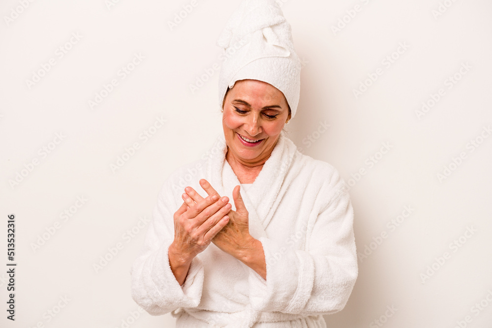 Middle age caucasian woman applying body cream isolated on white background Middle age caucasian woman applying body cream isolated on white background