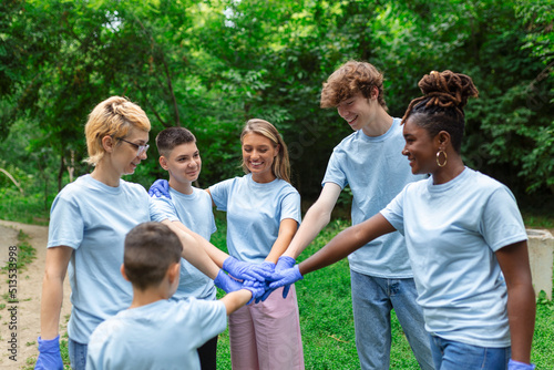 Portrait of volunteers folding their arms. Environmentalists are in a public park. They are in blue T-shirts. The concept of friendship and helping