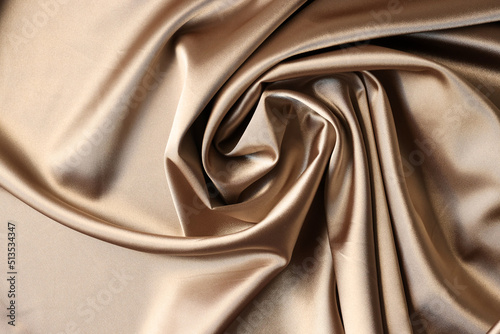 Beige satin fabric background. Texture of viscose is brown background photo