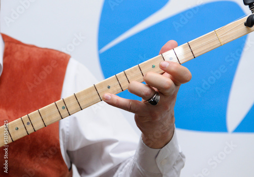 musician hand playing Turkic chordophone musical instrument baglama - saz photo