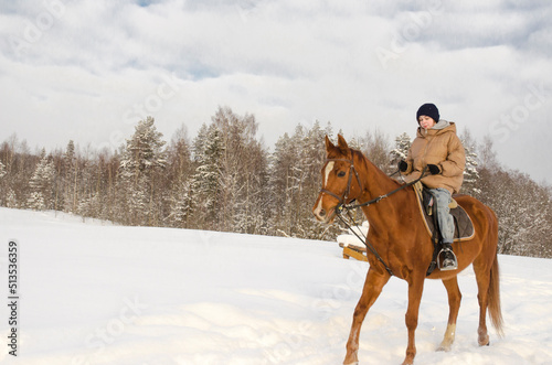 a girl rides a horse in the winter. winter holidays