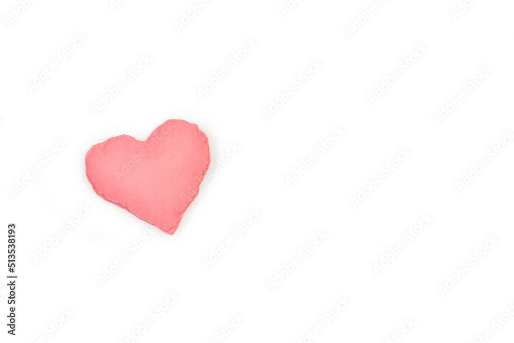 Un corazón rosa de tela hecho a mano sobre un fondo blanco liso y aislado. Vista superior y de cerca. Copy space