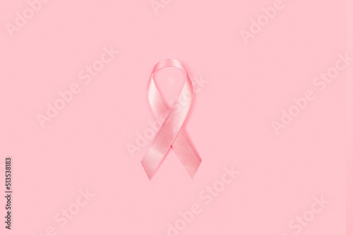 Lazo cinta rosa de concientización sobre el cáncer de mama sobre un fondo rosa pastel liso y aislado. Vista superior y de cerca. Copy space photo