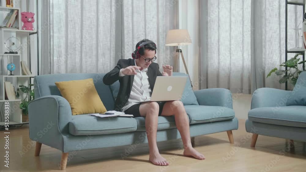 Full View Of Asian Businessman In Jacket And Shorts Listening To Music With Headphones And Dancing While Working With A Laptop At Home
Full View Of Asian Businessman In Jacket And Shorts Listening To Music With Headphones And Dancing While Working With A Laptop At Home