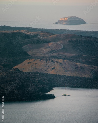 Vertical shot of the Nea Kameni island and Tholos Naftilos volcano in Greece before sunset photo