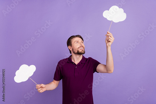Photo of young guy look paper poster imagination advertise curious isolated over violet color background © Tetiana