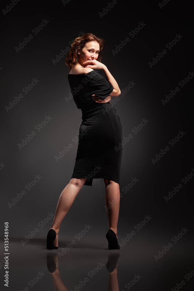 High fashion portrait of elegant woman in long black dress.