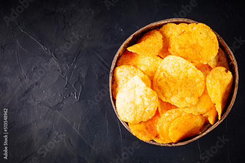 golden crispy potato chips on a dark background