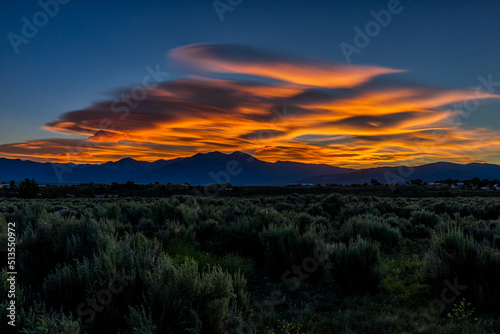 Foto Dark red sunrise and green desert sage brush plants in Ranchos de Taos valley la