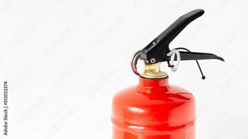 Red fire extinguisher on a white wall background Red fire extinguisher on a white wall background