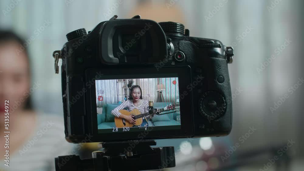 Close Up Of A Camera Monitor Recording Asian Woman Waving Hand And Speaking Before Playing A Guitar At Home
Close Up Of A Camera Monitor Recording Asian Woman Waving Hand And Speaking Before Playing A Guitar At Home