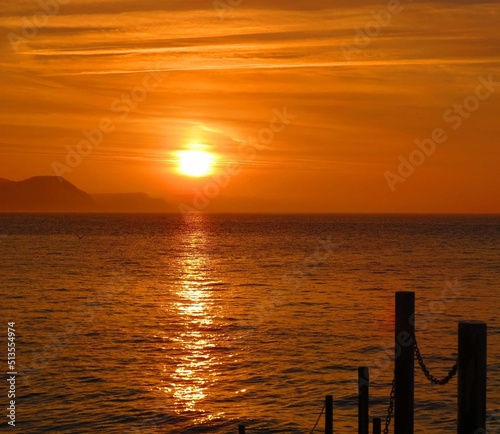 beautiful vivid orange sunrise over the sea and hills at Lyme Regis Dorset England
