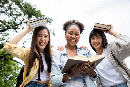 Diversity of happy woman student holding books and looking at natural outdoors at park. Prepare for college and university concept. Informal education and natural research