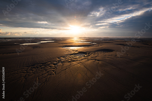 Distinctive dry and wet sand structures during low tide at a beach on Amrum island Germany during scenic sunset on a cloudy calm evening