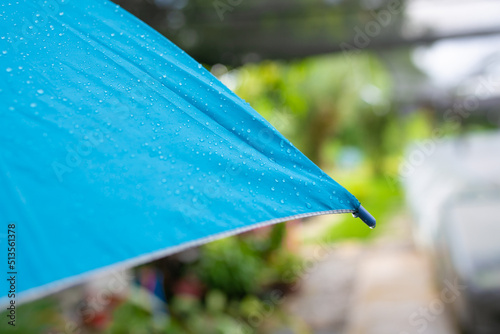 Rain drops on a blue umbrella.