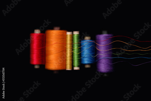 Unwound rainbow skeins of threads of LGBT flag colors isolated on black background. Preparing for a gay parade. Gay pride photo