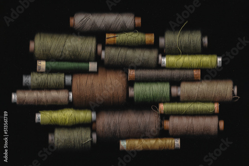 Set of spool of khaki threads for sewing military uniforms on a black background, green, brown colour threads, war, fashion atelie, clothes photo