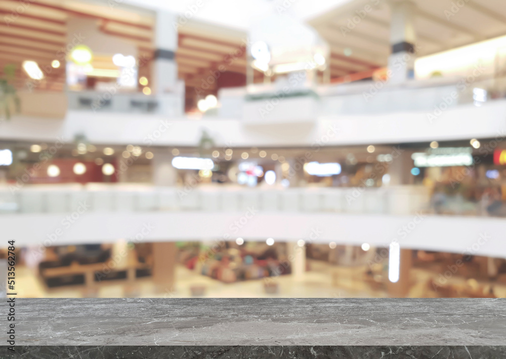 empty grey marble table in front of blurred background of shopping mall atrium can be used for display or montage your products. template for display of product. empty stone table space platform.