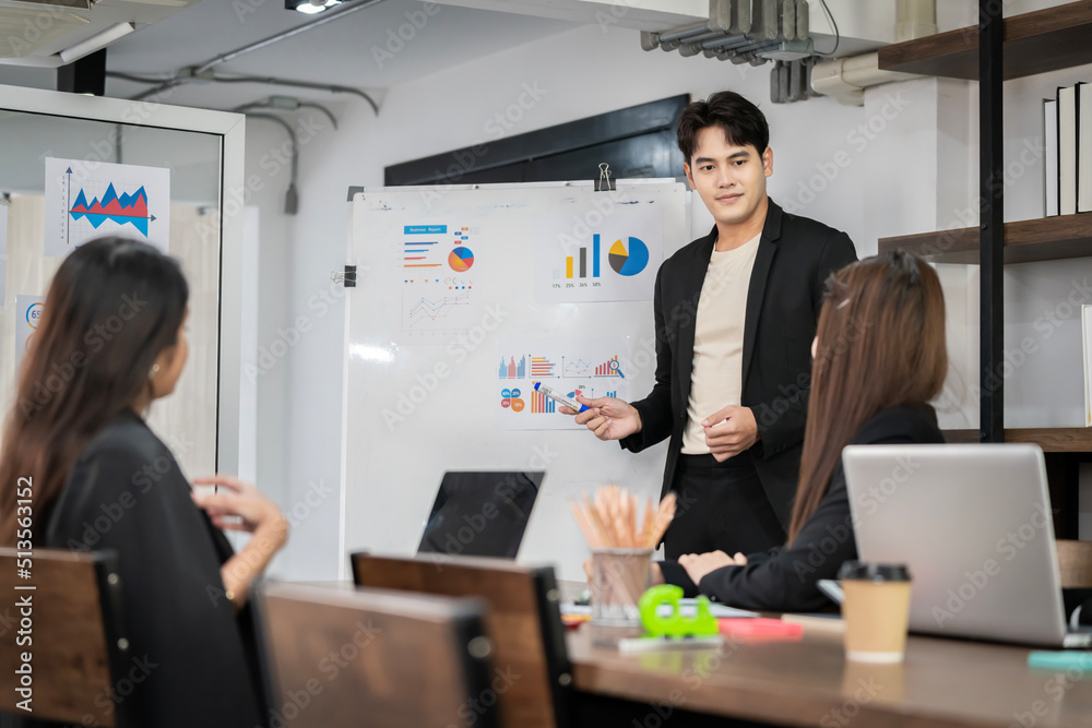 An Asian businessman is presenting his company performance report to his boss or group of male and female colleagues with confidence and professionalism. An Asian businessman is presenting his company performance report to his boss or group of male and female colleagues with confidence and professionalism.