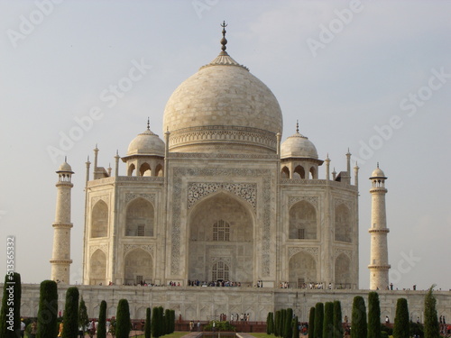 Taj Mahal, Agra, India, August 18, 2011: White marble mausoleum with four minarets and large domes seen from one of its fountains. Taj Mahal
