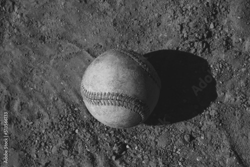 Baseball ball closeup on dirt field with retro style black and white.