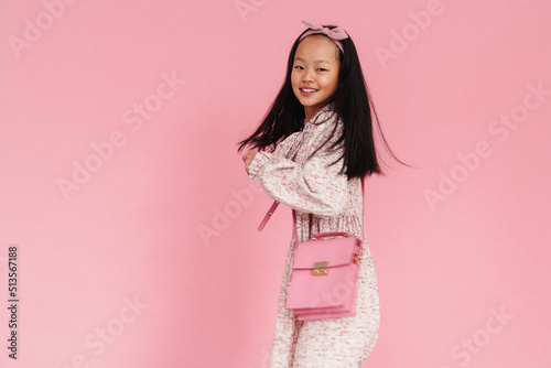 Asian preteen girl wearing dress smiling while looking at camera