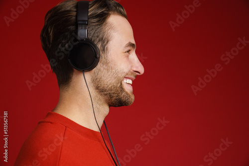 Young white man smiling while listening music with headphones