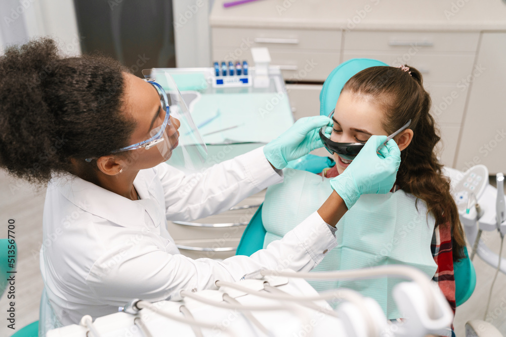 Black dentist working with patient in dental clinic Black dentist working with patient in dental clinic