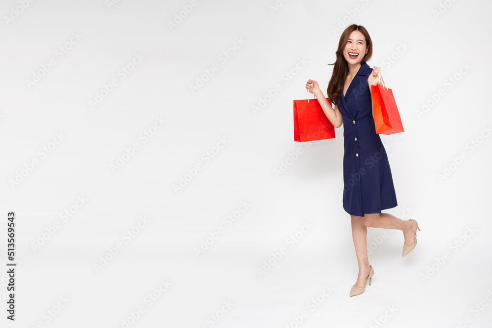 Portrait of young Asian woman walking and holding shopping bag isolated over white background, Full body composition Portrait of young Asian woman walking and holding shopping bag isolated over white background, Full body composition