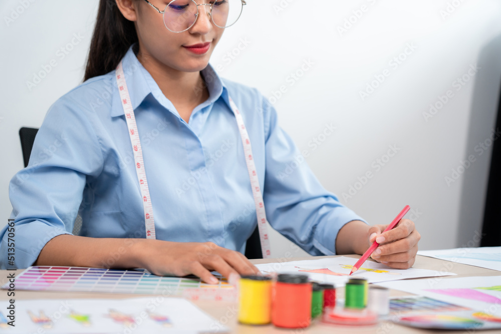 Professional women fashion designer stylist working and thinking decide making new clothes collection material product and choosing a color swatch