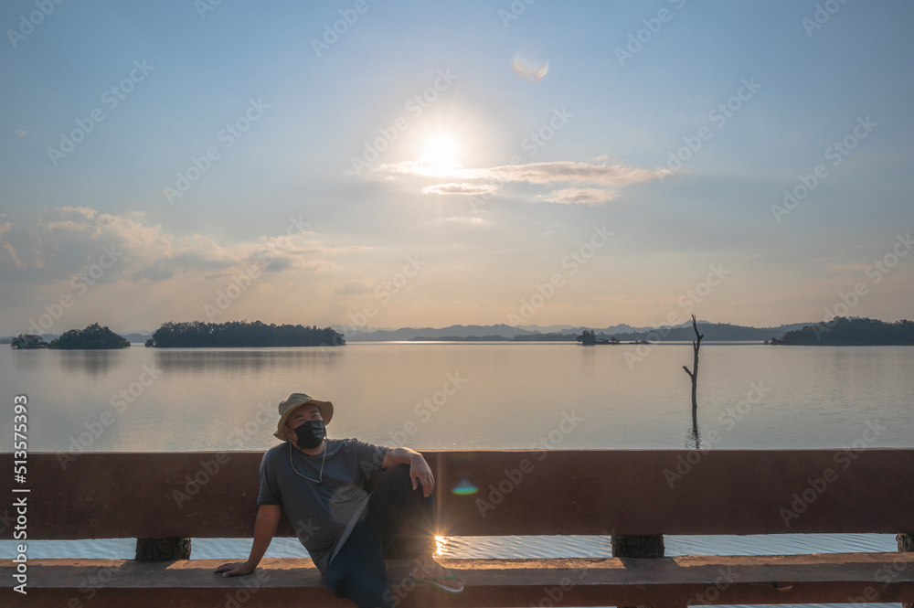 Fat man wearing mask with Landscape view of Pom pee view point.Pom Pee viewpoint is located in Khao Laem National Park, Thong Pha Phum district, Kanchanaburi province