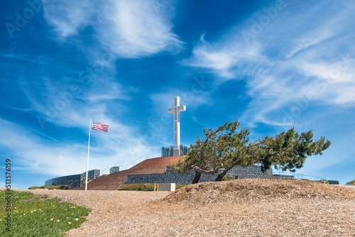 Beautiful shot of the Mt.Soledad National Veterans Memorial with a waving American flag in San Diego