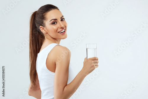 beautiful woman on isolated studio background, hold water glass. Drink water. Diet concept.