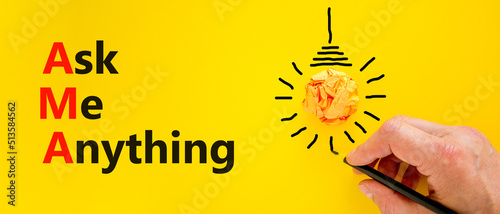 AMA ask me anything symbol. Concept words AMA ask me anything on yellow paper on a beautiful yellow background. Businessman hand. Business and AMA ask me anything concept. Copy space. photo