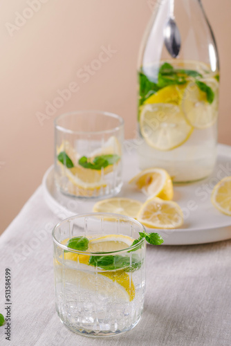 Refreshing summer drink with lemon and mint on the table. Lemonade in glasses and bottle