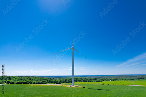 Panoramic shot from a bird's eye view of wind turbines in the middle of fields. Wind turbine construction in green field blue sky to generate renewable clean energy. concept idea eco energy energy.