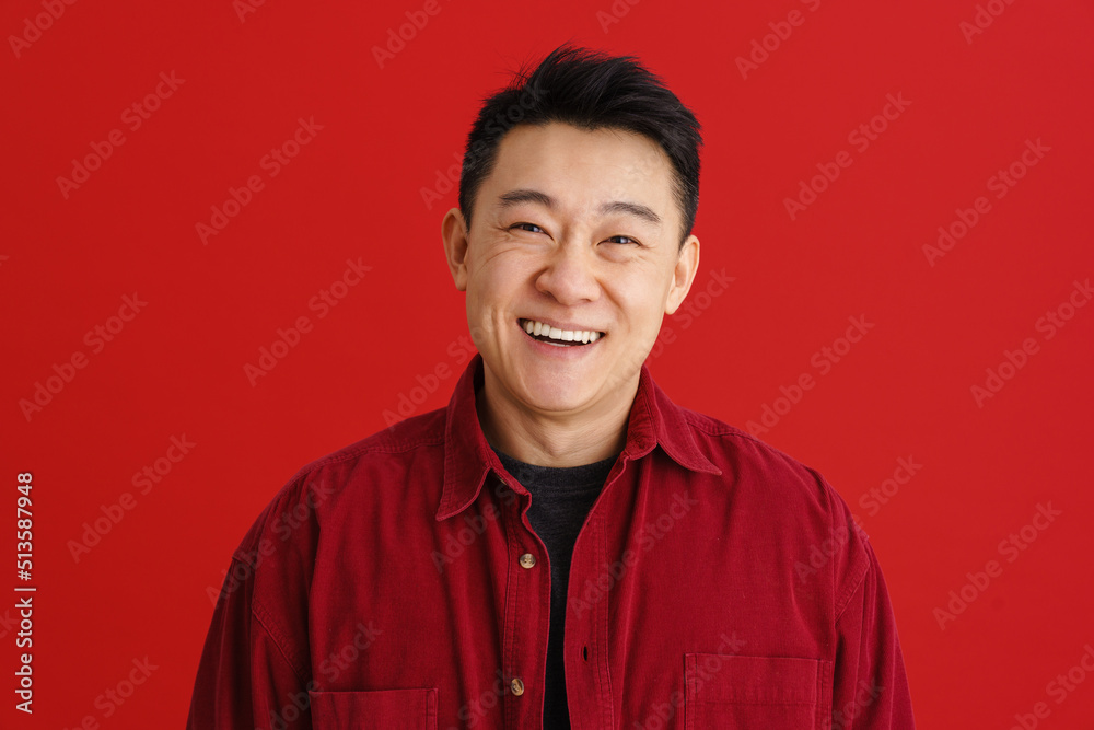 Brunette adult asian man wearing shirt smiling at camera Brunette adult asian man wearing shirt smiling at camera