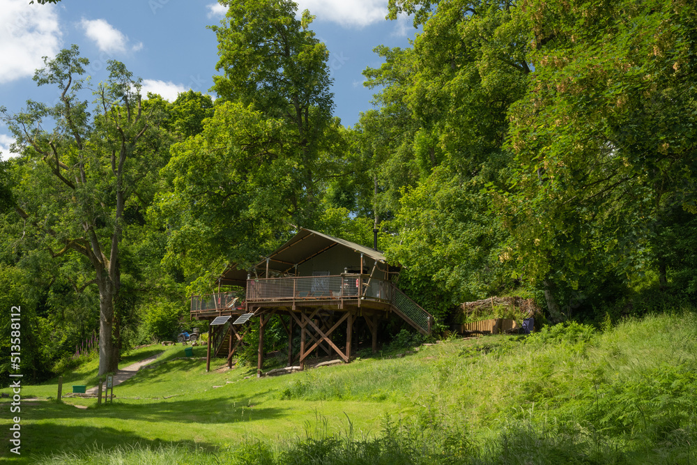 Wooden glamping tree top house with balcony on a grass field on Hay-on-Wye in Wales