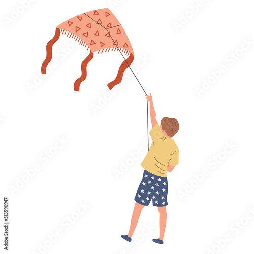 The boy stands with his back and launches a kite. The child is resting in the summer on vacation