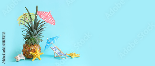 Image with ripe pineapple with parasol and beach chair over blue background. Summer holidays and tropical theme