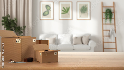 Wooden table, desk or shelf with stack of cardboard boxes over blurred view of white scandinavian living room with sofa, modern interior design, moving house concept with copy space © ArchiVIZ