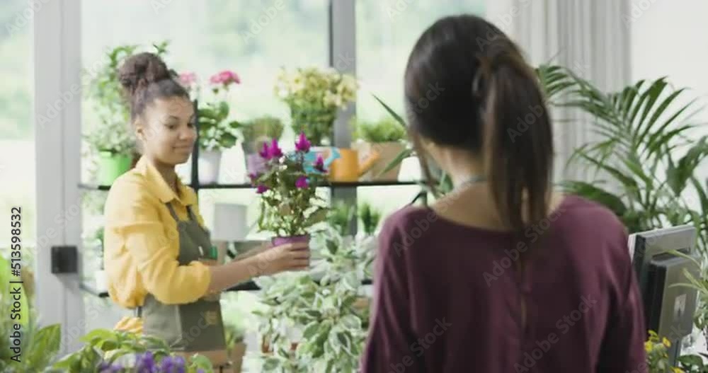Woman buying a plant at the flower shop Woman buying a plant at the flower shop