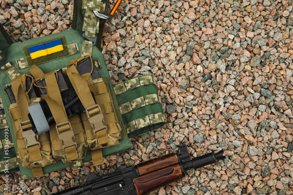 Military body armor and a Kalashnikov assault rifle. Body armor with