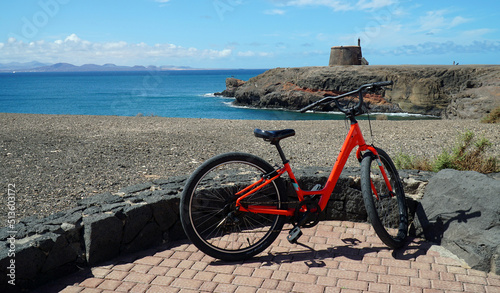 Bicycle on seafront promenade with sea, cliffs and Martello tower in background. photo