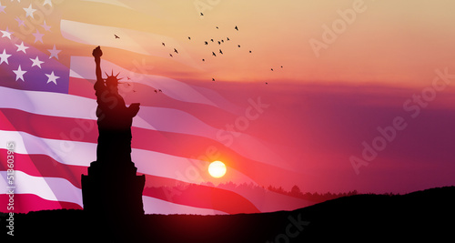 Statue of Liberty with a large american flag and sunset sky with flying birds on background. Greeting card for Independence Day. USA celebration.