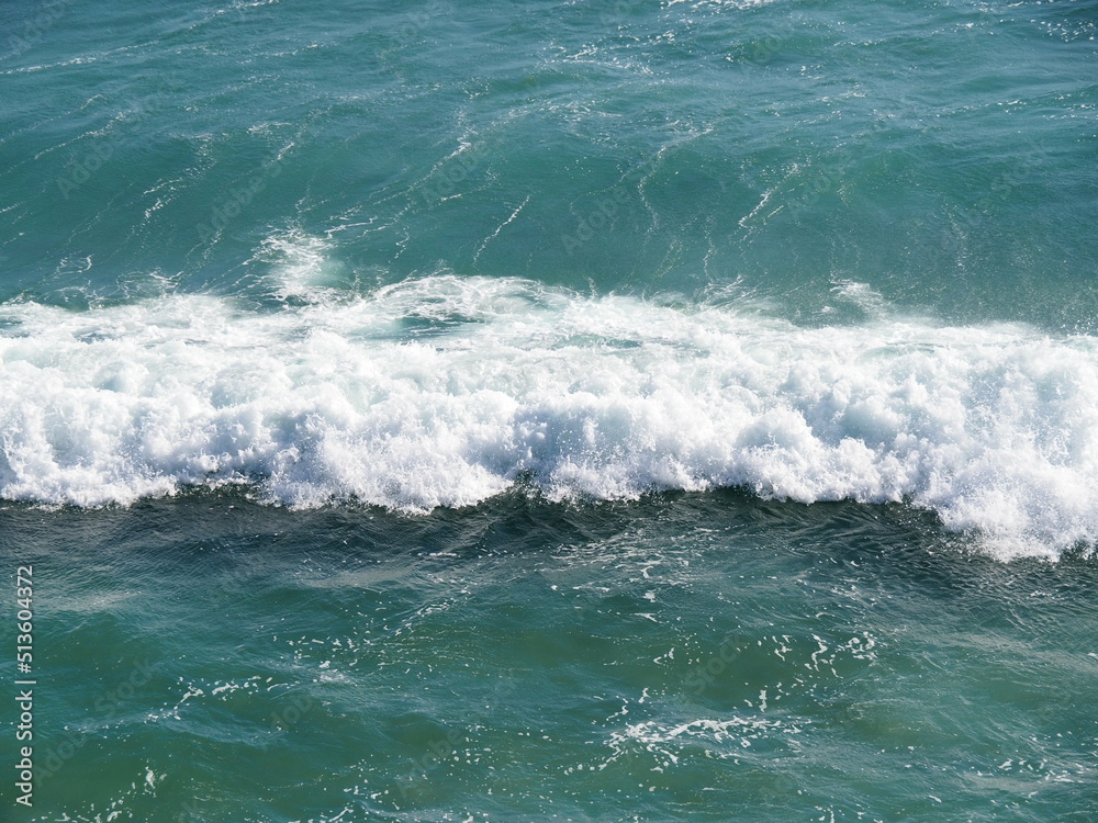 White waves crushing on blue sea