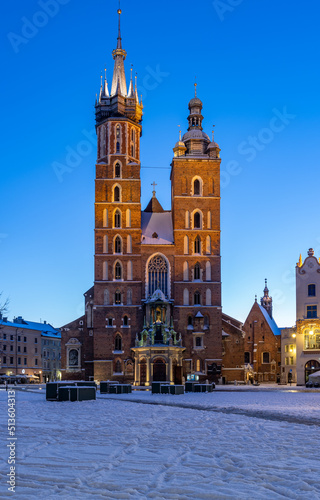St Mary's church on snow covered Main Square in winter Krakow, illuminated in the night. photo