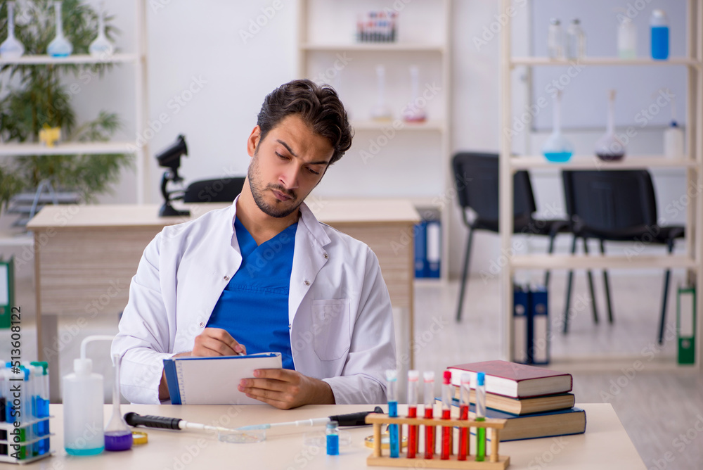 Young male chemist working at the lab Young male chemist working at the lab