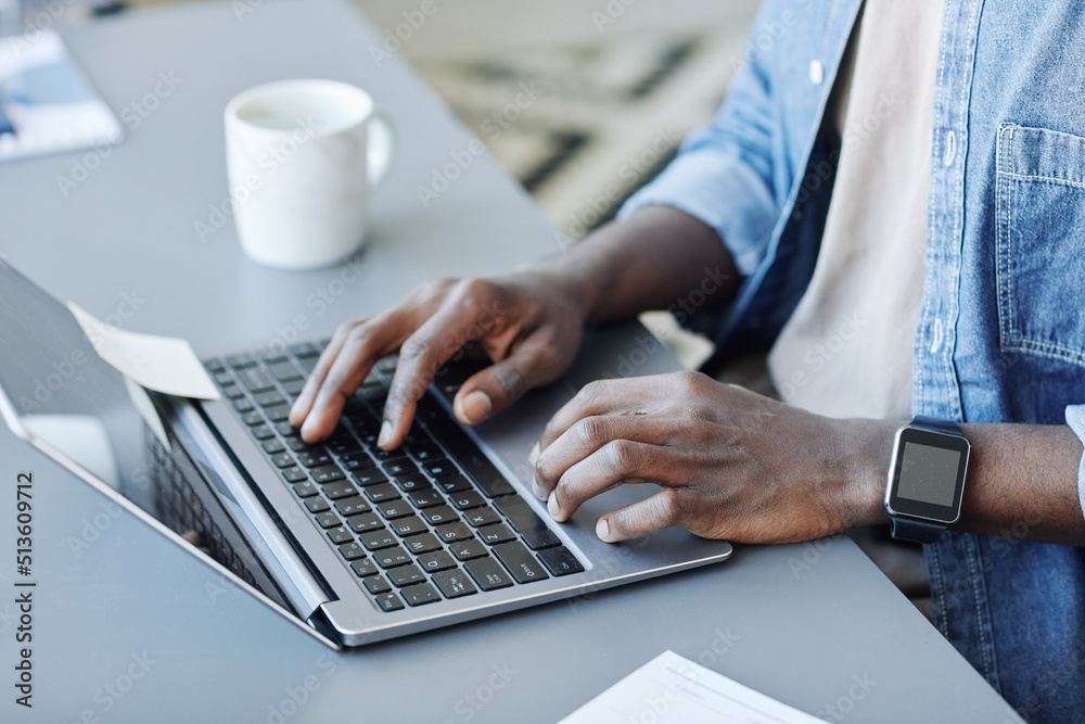 Close up of young black man typing at laptop keyboard while working remotely from home, copy space Close up of young black man typing at laptop keyboard while working remotely from home, copy space
