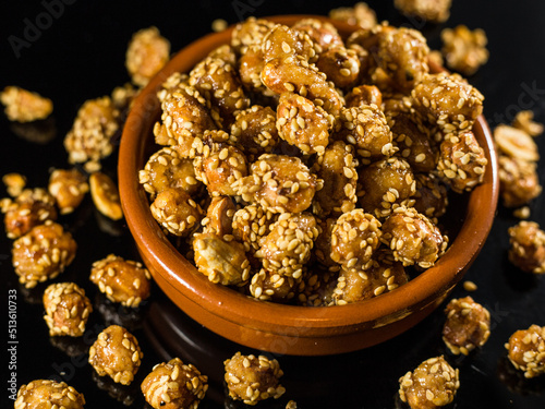 candied nuts with sesame seeds on a black background